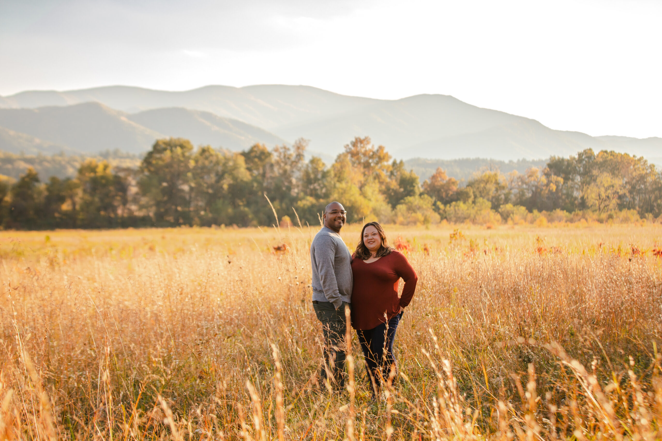 Colton Baker and his wife Jen in a field at sunset
