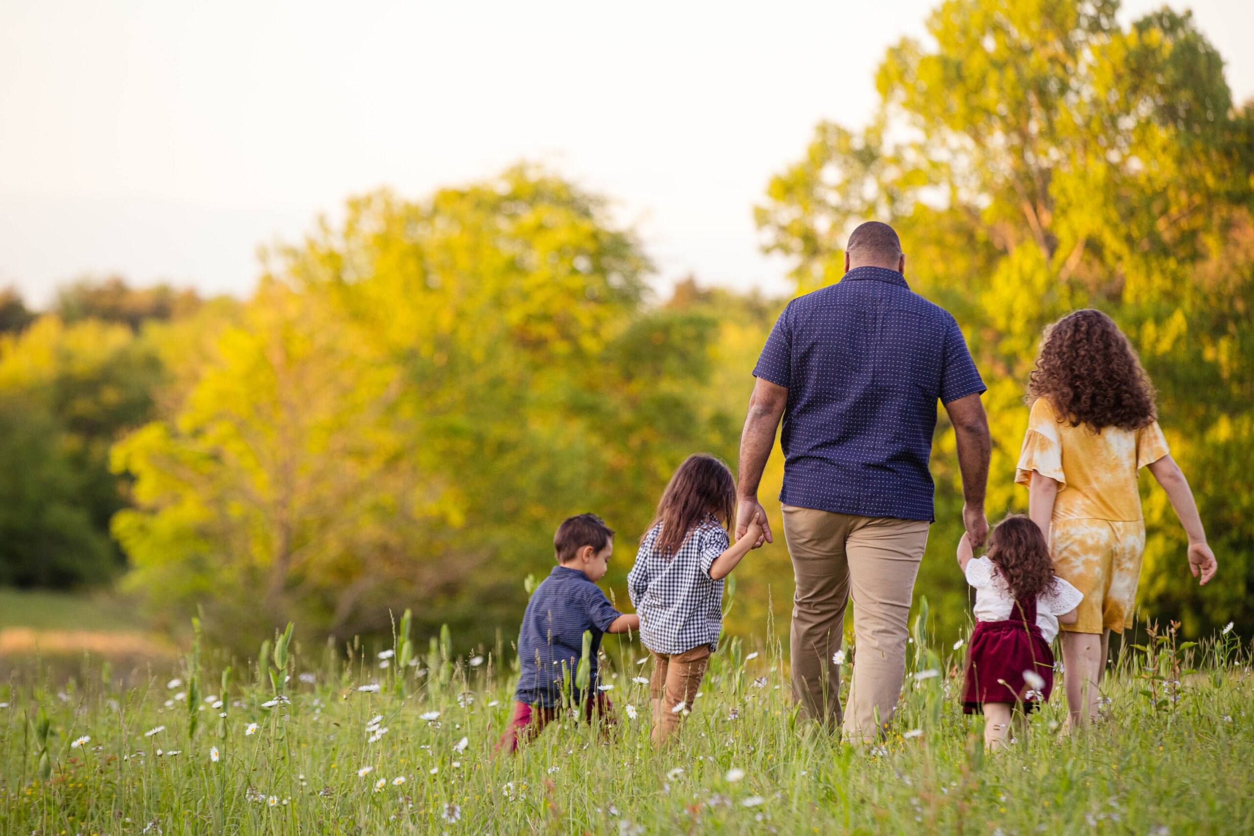 Colton Baker walking with his five children in a field